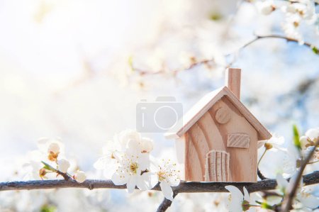 Foto de Blooming spring trees and miniature wooden house close up. Springtime greeting card and copy space - Imagen libre de derechos