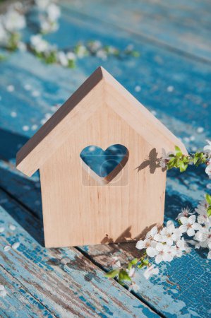 Téléchargez les photos : Blooming spring trees and miniature wooden house close up. Springtime greeting card and copy space. - en image libre de droit
