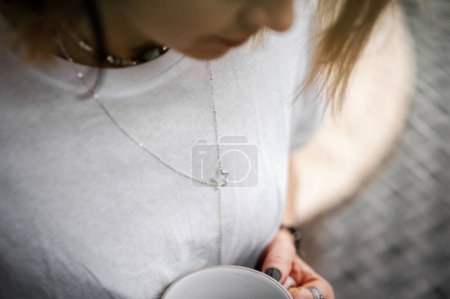 Foto de Mujer atractiva sentada pensativa y solitaria con taza de té de cerca y espacio de copia. Enfoque selectivo. - Imagen libre de derechos