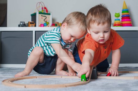 Téléchargez les photos : Two children boy play together with toys in interior of childrens room. - en image libre de droit