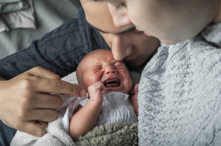 Foto de Newborn baby colic close up. Young parents and crying baby 1 month old. - Imagen libre de derechos