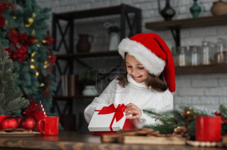 Photo for Merry Christmas and Happy New Year 2023. Happy girl opens gift on background of lights. - Royalty Free Image