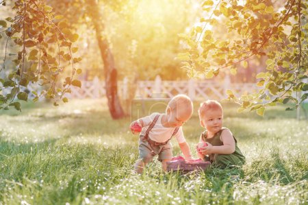 Foto de Dos niños pequeños y cosecha otoñal de manzanas. Niños niño y cesta de manzanas rojas maduras en el jardín primer plano y espacio de copia. - Imagen libre de derechos