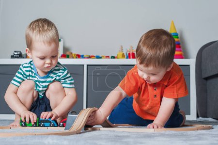 Photo for Two children boy play together with toys in interior of childrens room. - Royalty Free Image