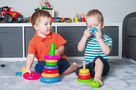 Téléchargez les photos : Deux enfants garçon jouer avec des jouets à l'intérieur de la chambre des enfants. - en image libre de droit