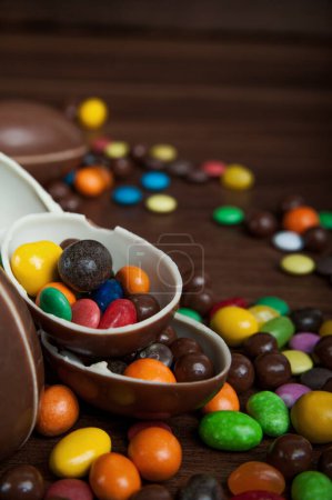 Foto de Composición de Pascua con deliciosos dulces, huevos de chocolate y lazo azul sobre fondo de madera, espacio para texto - Imagen libre de derechos