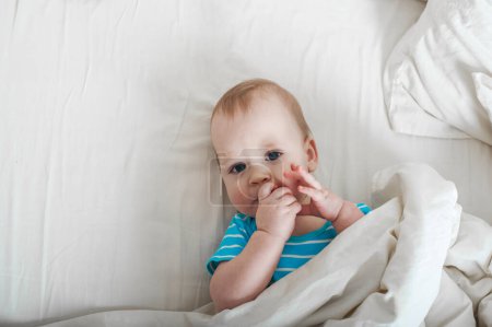 Téléchargez les photos : Bébé 11 mois sur le lit se préparer à dormir - en image libre de droit