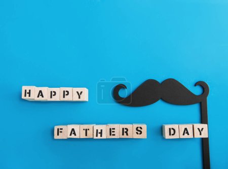 Téléchargez les photos : Inscription Happy Fathers Day and black mustache decor on blue background. - en image libre de droit