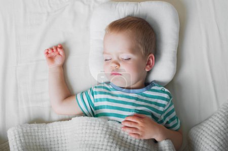 Téléchargez les photos : Petit garçon dormant en gros plan sur le lit. Concept de soins de santé. - en image libre de droit