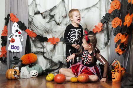 Téléchargez les photos : Enfants garçon et fille avec des citrouilles à la maison à Halloween. - en image libre de droit