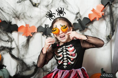 Photo for Girl with pumpkin fooling around at home on Halloween. - Royalty Free Image