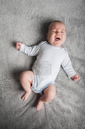 Neugeborenes Baby 2 Monate alt weint mit Neurodermitis Nahaufnahme Porträt. Babypflege, Koliken, Kinderkrankheiten, Weinen