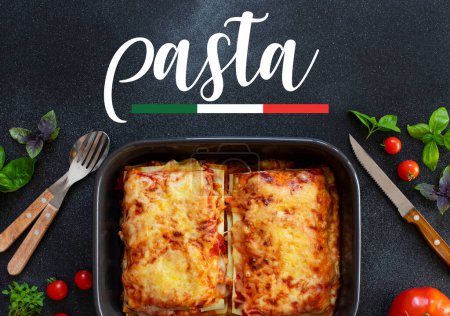 Téléchargez les photos : Lasagne italienne maison avec sauce tomate et viande, servie avec tomates et basilic. Deux portions. Fond sombre avec le mot pâtes. Vue de dessus. Espace de copie - en image libre de droit