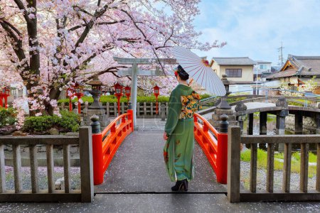 Foto de Joven mujer japonesa en vestido de Kimono tradicional con la pagoda Yasaka en el templo Hokanji en Kyoto, Japón durante la floración completa de la flor de cerezo en primavera - Imagen libre de derechos