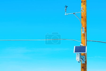 Photo for Solar panel and auxiliary equipment mounted on a wooden electric pole against a stunning blue sky with copy space. Renewable energy, sustainability and technology background. - Royalty Free Image