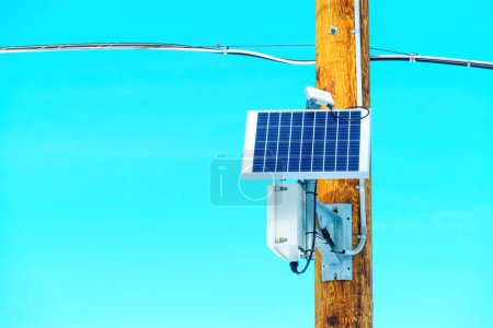 Photo for Solar panel and auxiliary equipment mounted on a wooden pole, generating renewable energy against a backdrop of clear blue sky. Contributing to a greener and more sustainable future. - Royalty Free Image