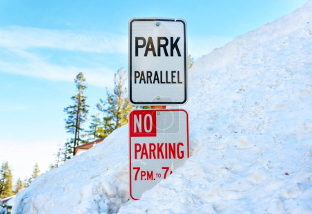 Photo for Winter sports and safety: Parking time and Park Parallel signs in a deep snowdrift. - Royalty Free Image