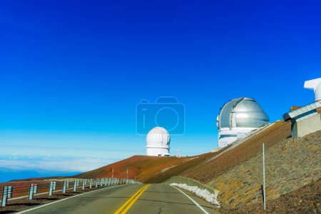 Photo for Astronomical research facilities at the summit of Mauna Kea, standing tall against a serene blue sky. - Royalty Free Image
