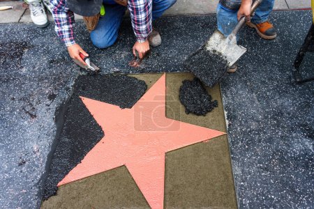 The process of placing a star on the Hollywood Walk of Fame in Los Angeles, California.