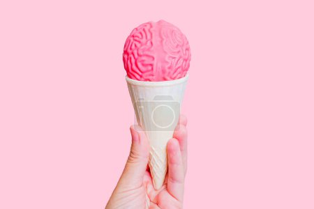 Photo for Ice cream cone topped with jelly-like human brain model in hand isolated on pink background. Mindful tasting adventure concept. - Royalty Free Image
