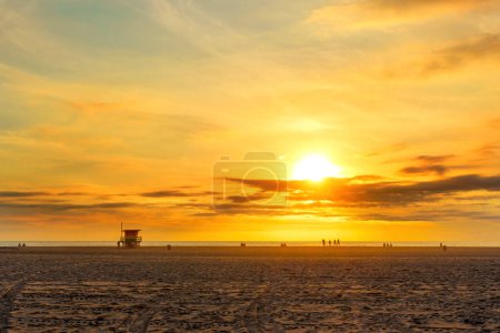 Photo for Awe-inspiring beauty of Venice Beach as unrecognizable beachgoers admire the setting sun. - Royalty Free Image