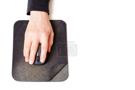 Photo for Close-up top view of a male hand using a computer mouse placed on an old and spoiled mouse pad isolated on white. - Royalty Free Image