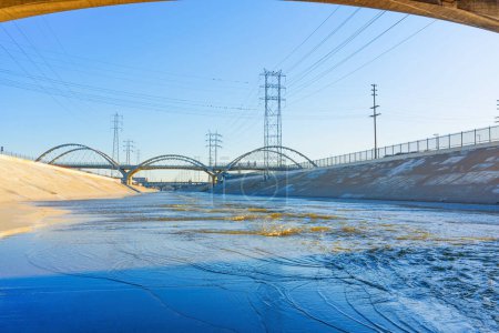 Photo for Wide angle view of the Los Angeles river concrete channel with iconic bridges and power lines. - Royalty Free Image