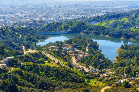 Foto de Vista aérea del embalse de Hollywood, sus pintorescos alrededores y la extensa ciudad de Los Ángeles capturada desde un mirador en la cima de una colina. - Imagen libre de derechos
