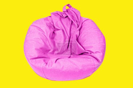 Nahaufnahme eines flachen rosafarbenen Beanensacks, isoliert auf gelbem Hintergrund. Wartungs- und Pflegekonzept für weiche Möbel.
