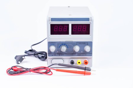 Front view of a laboratory DC power supply unit with leads and wires isolated on white.