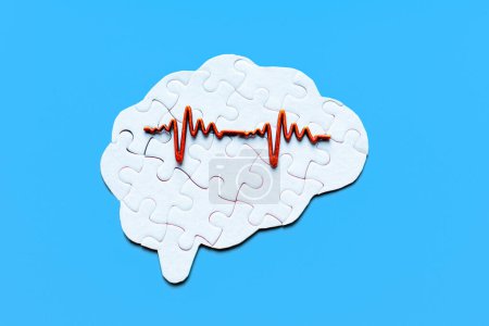 Human brain-shaped puzzle overlaid with an electroencephalogram (EEG) graph, set against a calming blue backdrop. Neuroscience, neurology, brain health, and cognitive research concept.