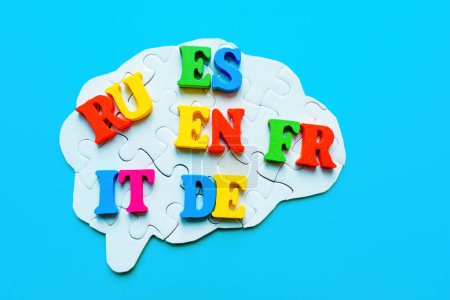 Brain-shaped puzzle adorned with vibrant wooden letters representing various languages: RU, ES, EN, FR, IT, DE. Mastering foreign languages.