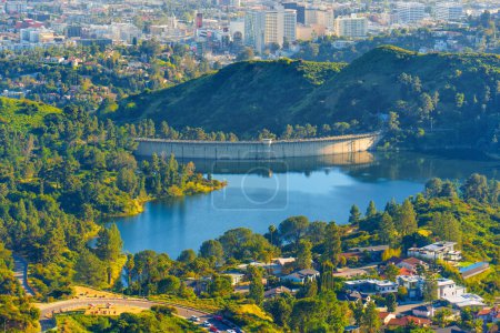 Nahaufnahme des Staudamms des Hollywood Reservoir, die vor dem Hintergrund benachbarter Häuser, Straßen und des fernen Stadtbildes komplizierte Details enthüllt.
