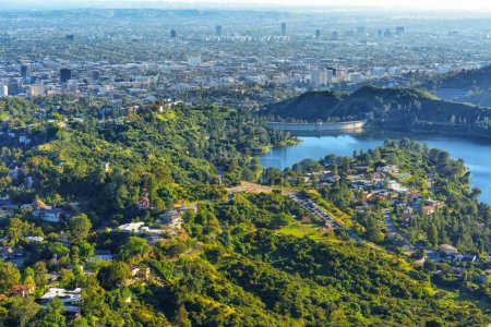 Foto de Perspectiva aérea de Los Ángeles, mostrando un tapiz de expansión urbana, exuberante vegetación, sinuosas carreteras y el emblemático embalse de Hollywood. - Imagen libre de derechos