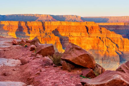 Blick auf die geschichteten Wände des Grand Canyon mit riesigen Felsen im Vordergrund.