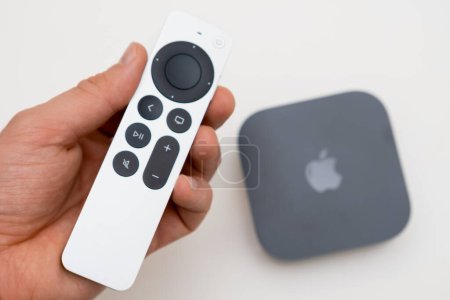 Téléchargez les photos : Man hand holds remote controller of Apple TV 4k with WiFi and Ethernet, February 2023, Prague, Czech Republic - en image libre de droit