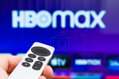 Photo for HBO Max on Apple TV showing on the screen of TV. Man hands switch on television using remote controller, Fabruary 2023, Prague, Czech Republic. - Royalty Free Image