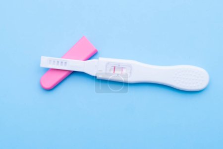 Téléchargez les photos : Test de grossesse positif sur fond bleu. Concept de soins de santé - en image libre de droit