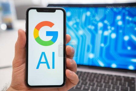 Téléchargez les photos : Logo Google AI du réseau neuronal sur l'écran du smartphone dans la main mans et ordinateur portable avec neuronette sur l'écran d'éclaboussure sur l'arrière-plan. Concept d'intelligence artificielle. - en image libre de droit