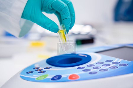 Téléchargez les photos : Insérer la cuvette dans le spectrophotomètre pour l'analyse d'ADN, microbiologique ou urinaire. - en image libre de droit