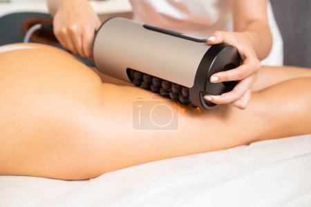 Téléchargez les photos : Traitement sculptant RSL des jambes et des fesses dans un salon cosmétique. - en image libre de droit