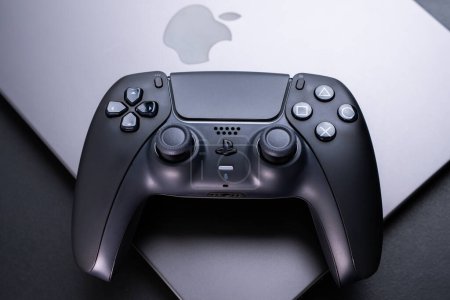 Photo for BERLIN , GERMANY - JANUARY 14 2024: A detailed view of a black DualSense controller placed on a Macbook Pro. - Royalty Free Image