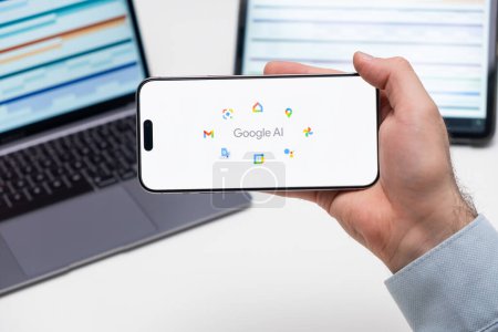 Photo for PRAGUE, CZECH REPUBLIC - JANUARY 21 2024: Google AI logo on the screen of a cell phone in business mans hand and laptop on the background. - Royalty Free Image