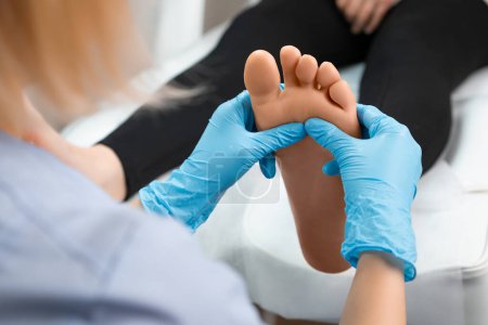 Photo for Close up of masseur doing foot reflexology massage to woman at beauty salon. - Royalty Free Image