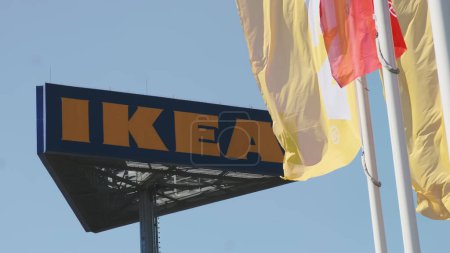 Téléchargez les photos : PRAGUE, CZECHIE - AVRIL, 2024 : Drapeaux IKEA agitant dans le vent contre le ciel et l'enseigne. - en image libre de droit