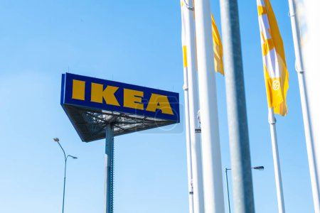 Téléchargez les photos : PRAGUE, CZECHIE - AVRIL, 2024 : Logo IKEA contre le ciel bleu et les drapeaux. - en image libre de droit