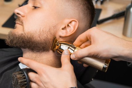 Téléchargez les photos : The hairstylist trims the brunette clients hair at the barbershop - en image libre de droit