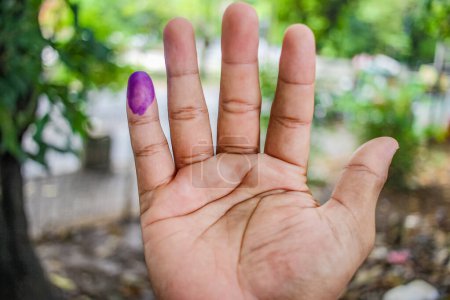 une photo de la main d'un homme. L'encre sur le doigt d'un homme a été obtenue après avoir voté lors des élections régionales (pilkada) à Semarang, en Indonésie
