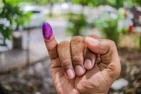 une photo de la main d'un homme. L'encre sur le doigt d'un homme a été obtenue après avoir voté lors des élections régionales (pilkada) à Semarang, en Indonésie