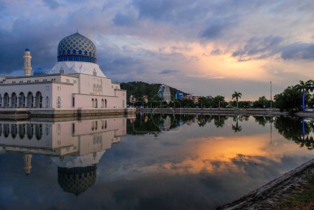 Foto de Puesta de sol sobre la mezquita de la ciudad de Kota Kinabalu en Sabah, Malasia, reflejada en una laguna - Imagen libre de derechos
